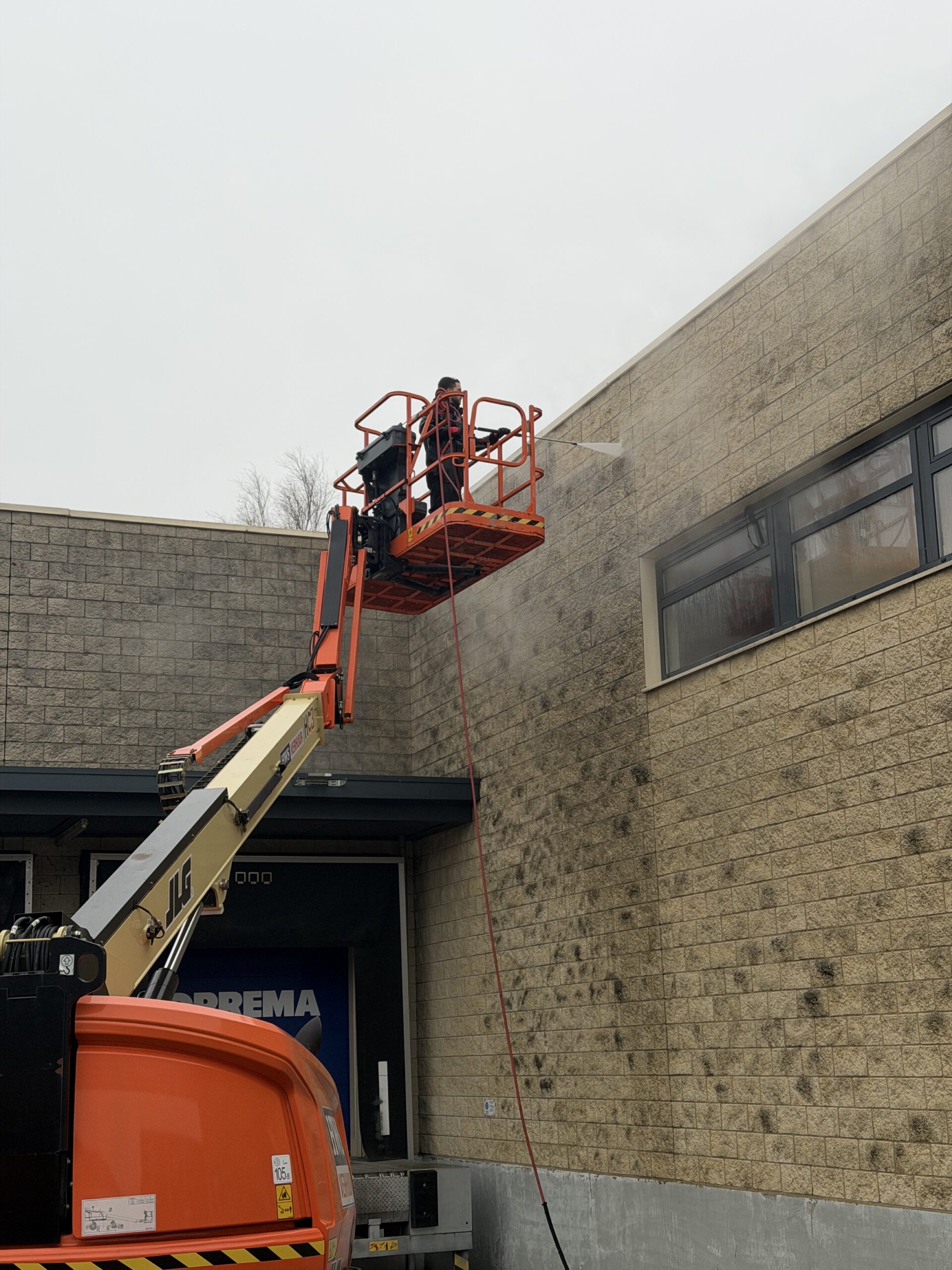 Muur schoonmaken met hoogwerker